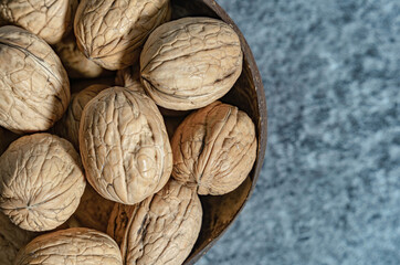 A bowl with whole walnuts in shells. Fresh organic nuts. Overhead view.