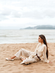 Fototapeta na wymiar Solitary Beauty: A Young Woman Enjoying the Ocean Breeze, Admiring the Serene Sunset on a Sand Beach Chair