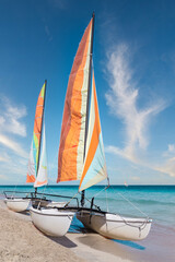Colorful sailing catamaran on the beach of the Varadero -  Cuba.
Turquoise blue Atlantic water and blue sky with white clouds.