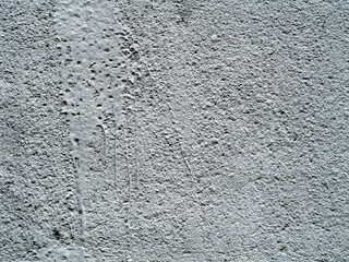 There is a stain of paint with smudges and cracks on gray rough plaster. Abstract monochrome background. Copy space.