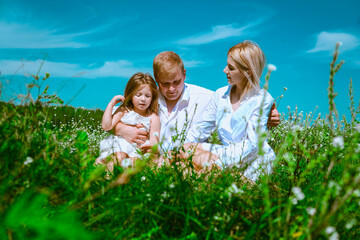 A family are walking and playing on a summer meadow. Blue sunny sky and funny emotion