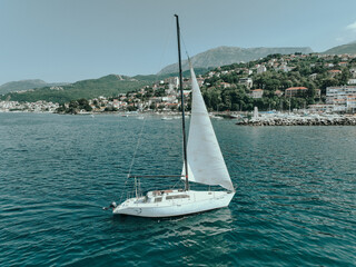 Sailing Boat on Crystal Blue Water by Coastal Town