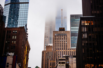 Fototapeta premium Skyscrapers seen in clouds and foggy weather in Manhattan, New York City, United States.