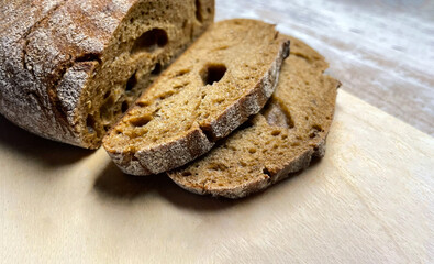 the fresh smell of black bread on a wooden board, delicious crispy bread close-up - macro photography, a product for breakfast, lunch and dinner, delicious flour product, dietary