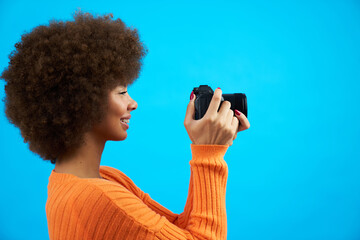 profile view Afro-haired latina woman with smile and determined look, capturing moments