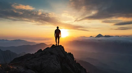 Deurstickers Hiker standing on the top of peak and looking at majestic sunset of wild unapproachable mountain range. Adventure in nature concept.  © triocean