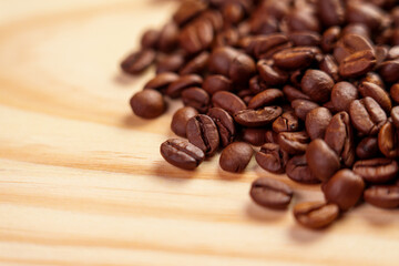 Brown roasted colombian coffee grains on a grained wooden surface
