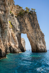 Rocky Arch in Ionian Sea in Zakynthos. Vertical Scenery of Keri Cave in Greece. Stony Cliff with Turquoise Water in Summer Europe.