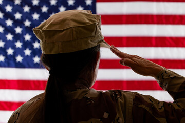 Female Soldier saluting the American Flag with shallow depth of field