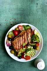 Grilled chicken fillet with fresh vegetable salad. Top view with copy space.