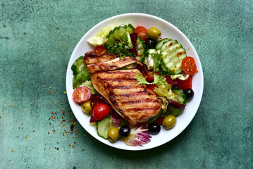 Grilled chicken fillet with fresh vegetable salad. Top view with copy space.
