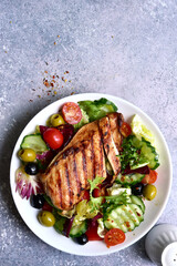 Grilled chicken fillet with fresh vegetable salad. Top view with copy space.