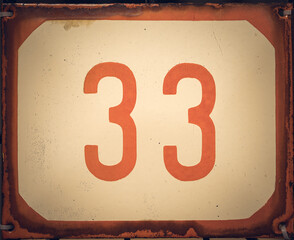 Red and white weathered grunge square metal enameled plate of number of street address with number 33