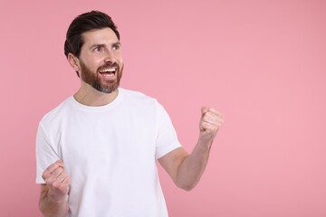 Portrait of happy surprised man on pink background, space for text