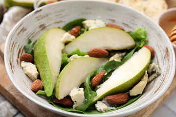 Delicious pear salad in bowl on table, closeup