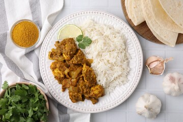 Delicious chicken curry with rice and ingredients on white tiled table, flat lay