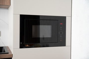 Black built-in microwave oven in kitchen furniture