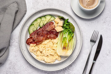 Food photography of breakfast; scrambled egg; fried bacon, cucumber, bok choi; cheese parmesan, keto diet; brunch;  background