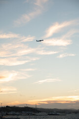 Fototapeta na wymiar Aeroplane taking off at sunset over the sea