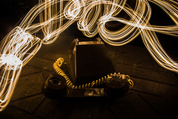 old black telephone on old wood plank with art dark background with fog and toned light. empty...