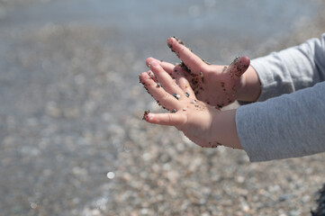 hands of a toddler on sand