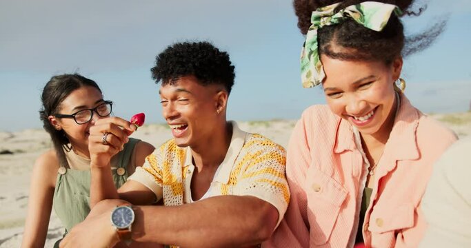 Friends, beach and picnic on holiday with fruit during happy conversation while bonding with care. Coast, food and diverse young people eating strawberry on a summer vacation while hungry with toast
