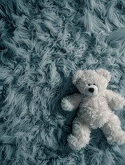 A teddy bear on a fluffy blue rug, symbolising comfort and childhood.