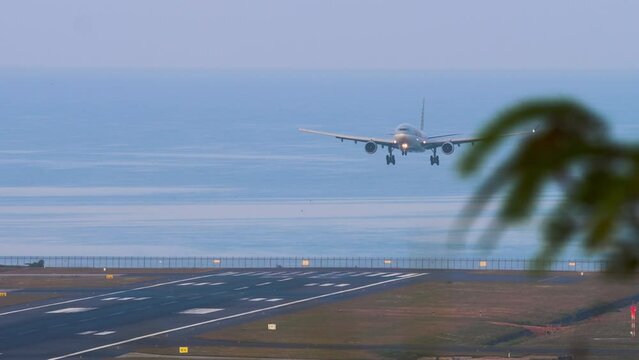 Passenger plane landing from the sea, front view. Airfield on the coast of the island