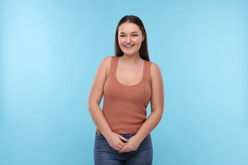 Smiling woman with dental braces on light blue background