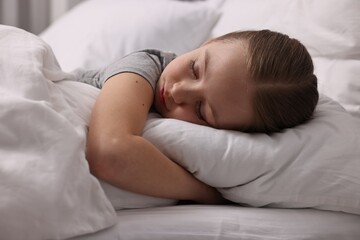 Little girl suffering from headache in bed