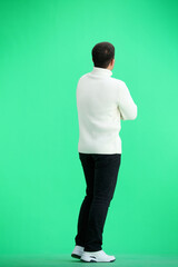 Fototapeta na wymiar A man, full-length, on a green background, crossed his arms
