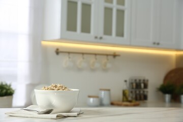 Fototapeta na wymiar Breakfast time. Tasty oatmeal in bowl on white marble table. Space for text