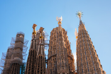 Closeup of Sagrada Familia's spires against a blue sky in Barcelona, showcasing Gaudi's Modernisme...
