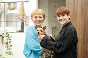 ドッグサロンでヨークシャーテリアを抱く女性スタッフたち