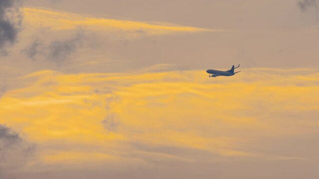 The plane against the blue sunset sky. Aircraft departure. Plane leaving. The setting sun. Sunset