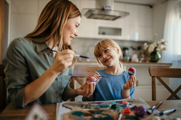 A mom and daughter immersed in the art of egg decorating