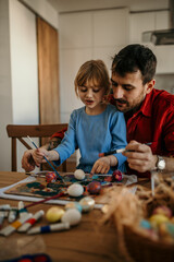 Naklejka premium Dad and daughter bonding over a creative Easter egg decorating session, full of colorful paints and festive anticipation