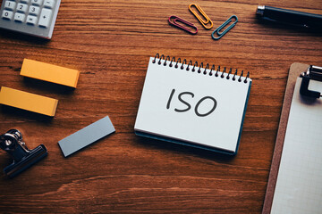There is notebook with the word ISO. It is an abbreviation for International Organization for Standardization as eye-catching image.