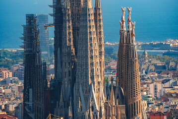 Closeup of Sagrada Familia's spires in Barcelona, showcasing Gaudi's Gothic and Art Nouveau design,...