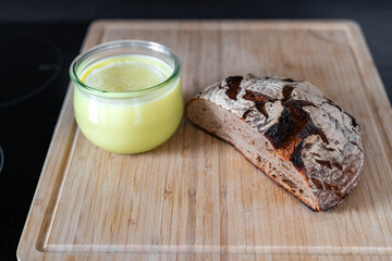 Selbstgemachte Vegane Butter zu Hause in der Küche neben einem Brot auf einem Holzbrett
