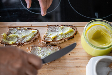 Selbstgemachte Vegane Butter zu Hause in der Küche Männer Hand streicht sie auf Holzbrett auf ein Brot