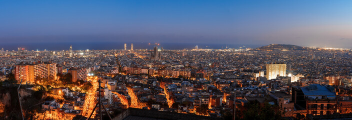 Twilight descends on Barcelona, with city lights twinkling against the dusk. The Sagrada Familia...