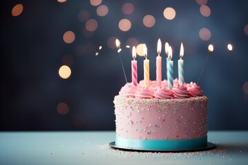 Birthday cake with burning candles on table against bokeh background
