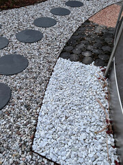 Modern garden design: round slabs laid in pebbles and a barefoot path