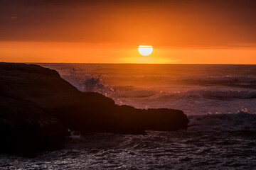 Sun falling behind the waves
