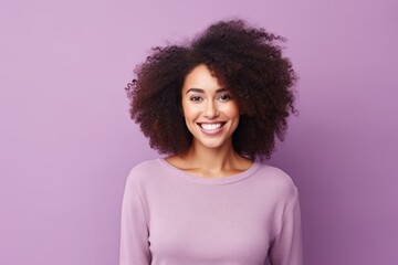 Portrait of a beautiful young african american woman smiling at camera against purple background