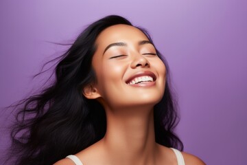 beauty, people and health concept - smiling young asian woman with closed eyes over violet...