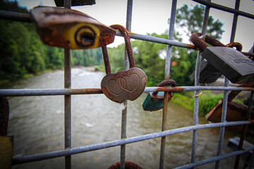 love padlocks, Valentine's Day, rusty padlocks, progressive corrosion, padlocks on the bridge, lovers' day, close-up view, flowing river in the background,


