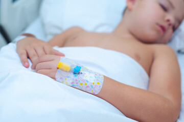 Little 7-8 year old boy sleeps with a catheter in his hand in the hospital - 728134727
