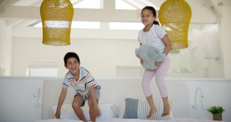 Children, girl and boy with jumping on bed, laughing and teddy bear with bonding on holiday in house. Kids, bedroom and excited for comic games, brother and sister with toys, happy and family home - Powered by Adobe